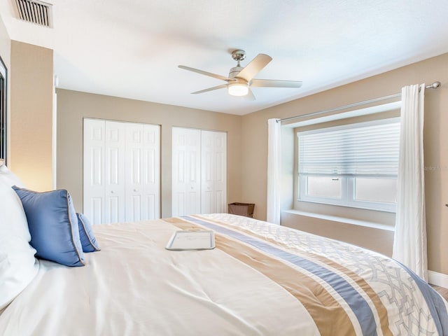 bedroom featuring ceiling fan and two closets