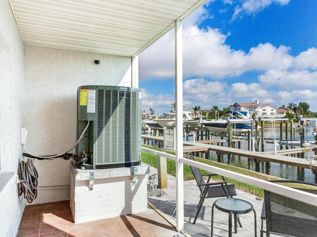 balcony featuring a water view, a dock, and central air condition unit