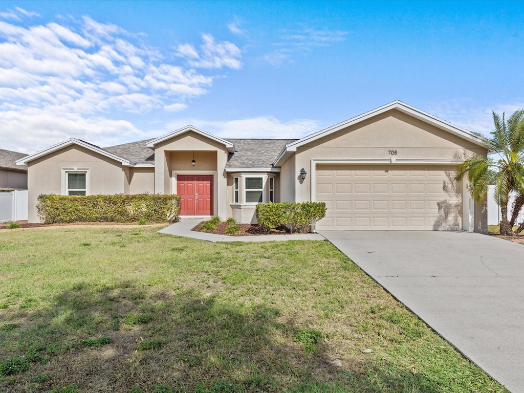 ranch-style house featuring a front lawn and a garage