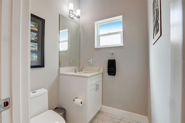 bathroom with plenty of natural light, vanity, and toilet