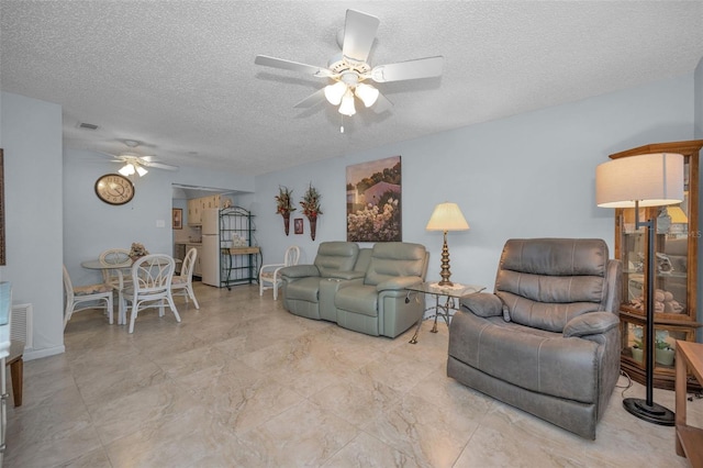 living room featuring a textured ceiling and ceiling fan