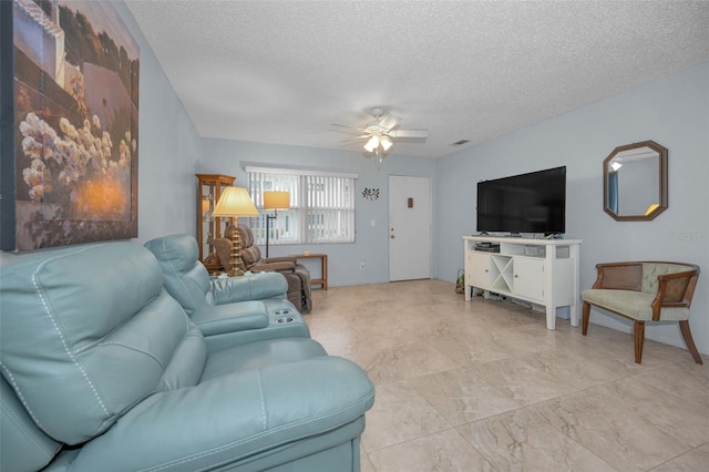 living room featuring ceiling fan and a textured ceiling