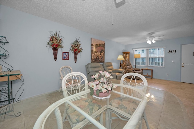 tiled dining room with ceiling fan and a textured ceiling