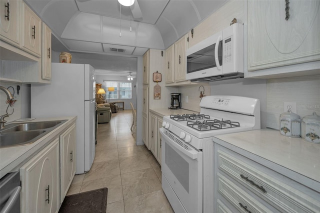 kitchen with ceiling fan, sink, white appliances, and light tile patterned flooring