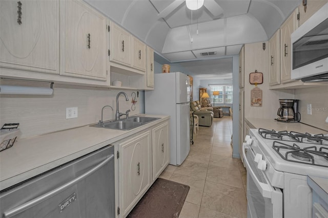 kitchen featuring light tile patterned floors, ceiling fan, tasteful backsplash, white appliances, and sink