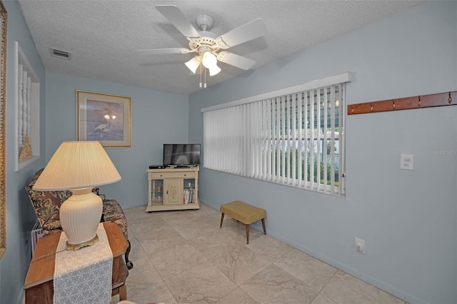 interior space featuring a textured ceiling and ceiling fan