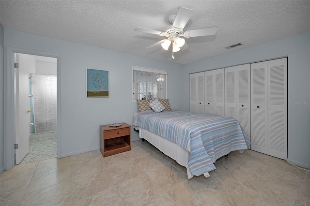 bedroom with ceiling fan, a textured ceiling, ensuite bathroom, and a closet