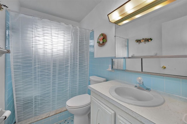 bathroom featuring tile patterned floors, vanity, tile walls, toilet, and walk in shower