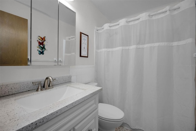 bathroom featuring tile walls, toilet, and vanity