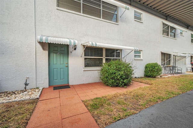 property entrance featuring a patio area