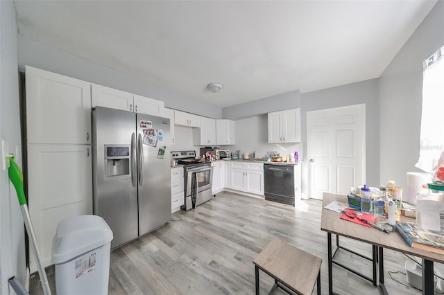 kitchen with white cabinets, light wood-type flooring, and appliances with stainless steel finishes