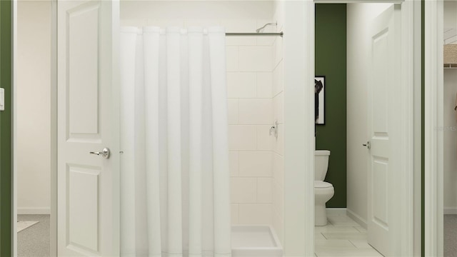 bathroom with toilet and a tile shower