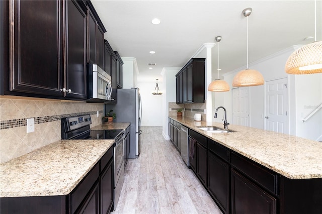 kitchen with backsplash, decorative light fixtures, sink, and stainless steel appliances