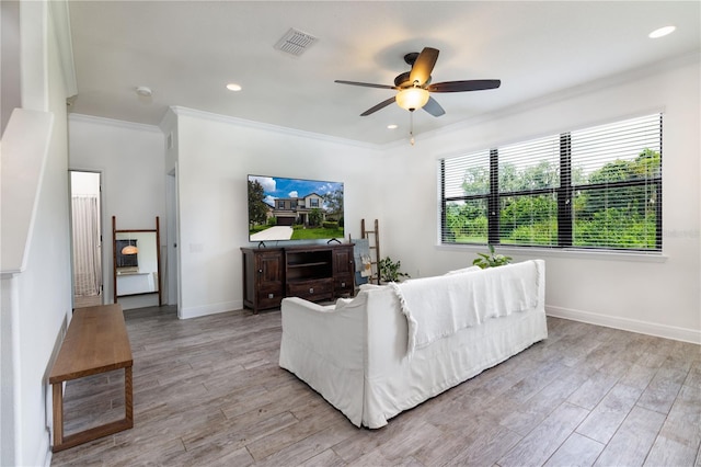 living room with crown molding, light hardwood / wood-style flooring, and ceiling fan