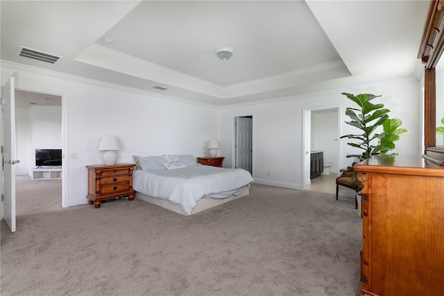 carpeted bedroom with crown molding, connected bathroom, and a tray ceiling