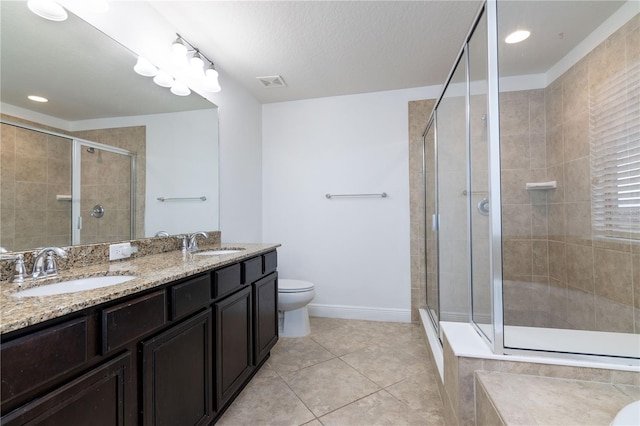 bathroom with vanity, toilet, tile patterned flooring, and walk in shower