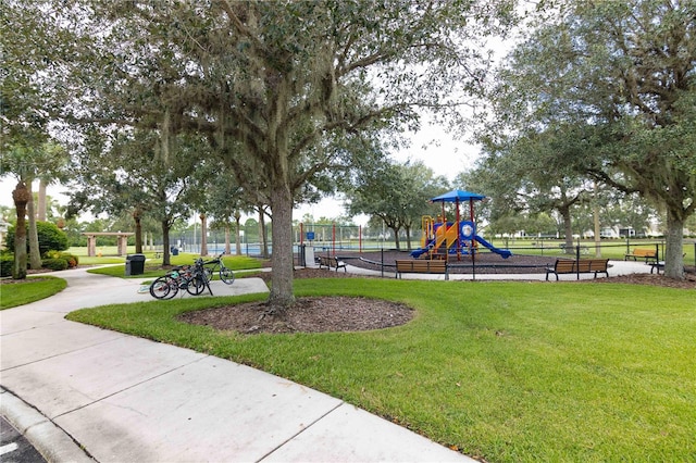 view of home's community with a playground and a yard