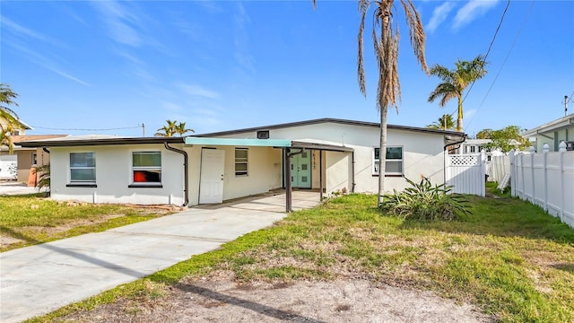 view of front of home with a carport and a front lawn