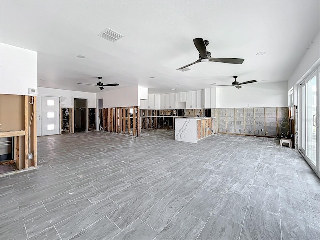 unfurnished living room with ceiling fan