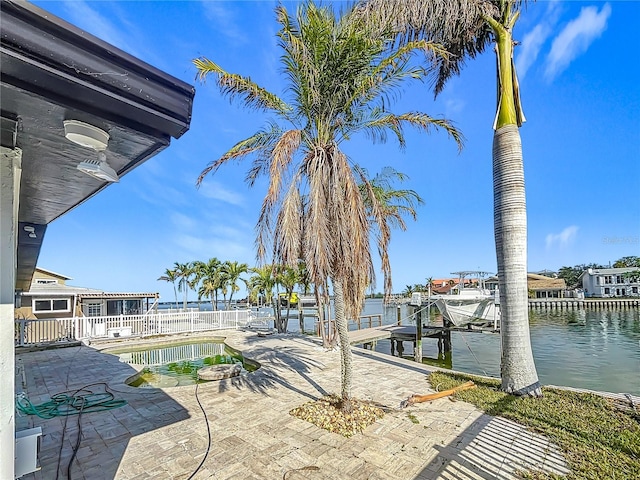 view of patio / terrace featuring a water view, a dock, and a hot tub