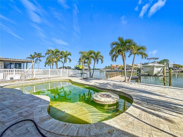 view of swimming pool featuring a boat dock and a water view