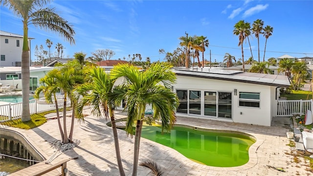 exterior space featuring solar panels, a patio, and a fenced in pool