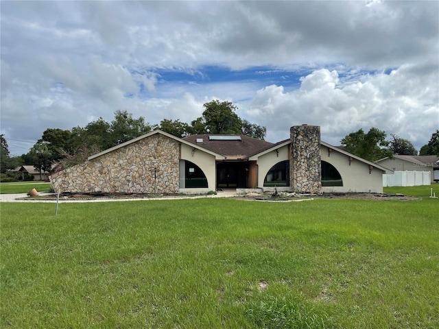 single story home featuring a front yard and solar panels