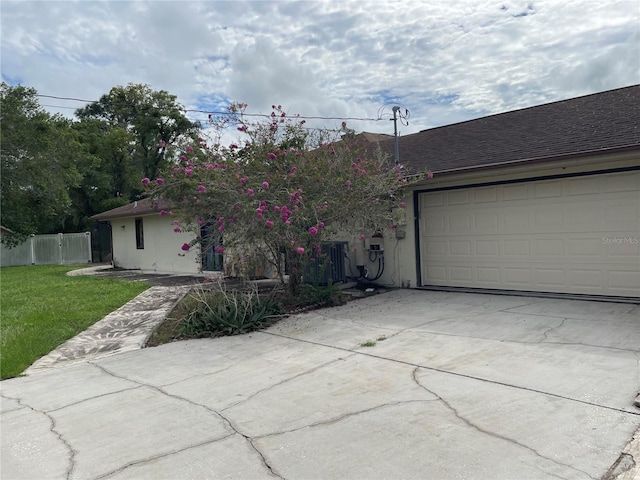 single story home with a garage and a front lawn