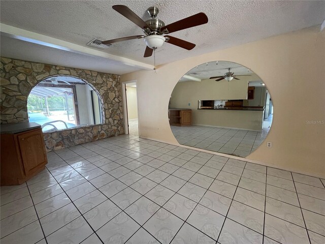 tiled spare room featuring ceiling fan and a textured ceiling