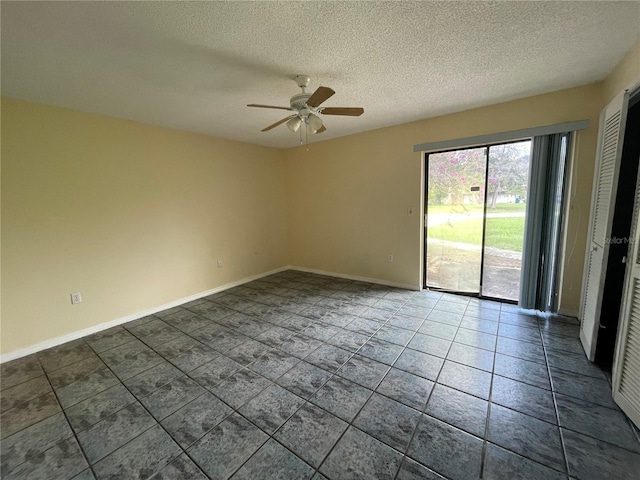 unfurnished room with ceiling fan and a textured ceiling