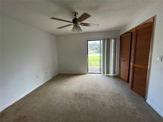 unfurnished bedroom featuring ceiling fan, carpet floors, a textured ceiling, access to outside, and a closet