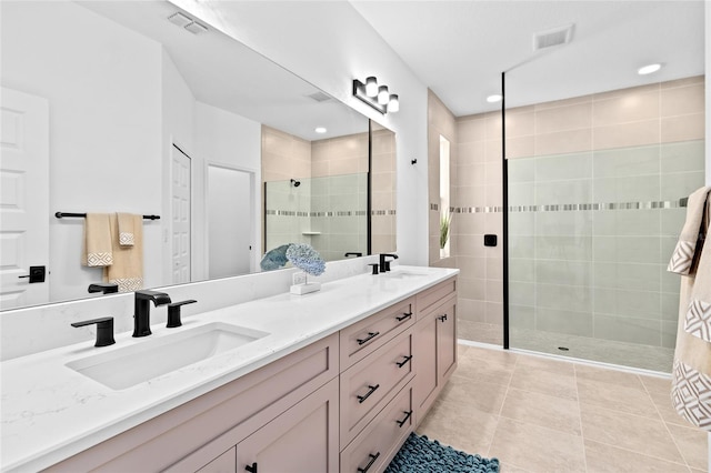 bathroom featuring tiled shower, vanity, and tile patterned floors