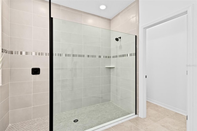 bathroom featuring tile patterned flooring and a tile shower