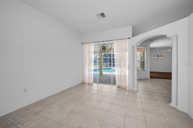 unfurnished room featuring ornate columns, ceiling fan, and light tile patterned floors