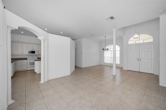 tiled foyer with a chandelier