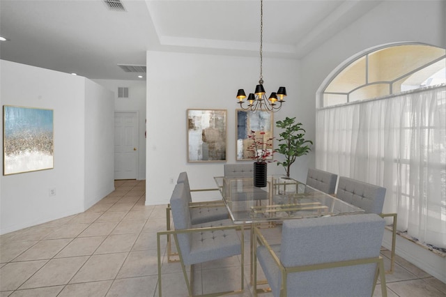 tiled dining room with a notable chandelier and a raised ceiling