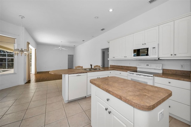 kitchen with white appliances, sink, light tile patterned floors, a center island, and white cabinetry