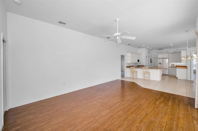 unfurnished living room featuring ceiling fan and light hardwood / wood-style floors