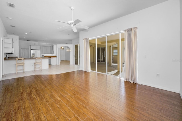 unfurnished living room featuring light wood-type flooring and ceiling fan