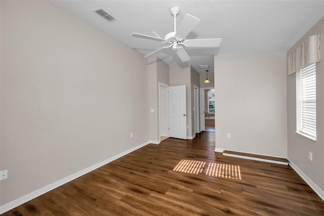 empty room with ceiling fan, dark wood-type flooring, a wealth of natural light, and vaulted ceiling