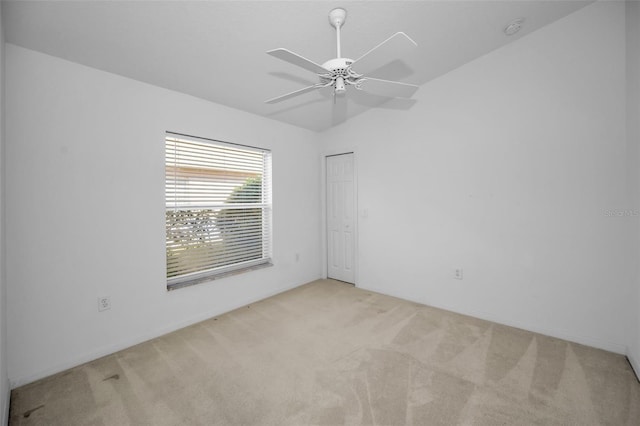 carpeted spare room with ceiling fan