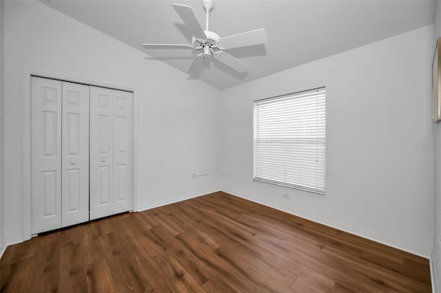 unfurnished bedroom with ceiling fan, dark hardwood / wood-style flooring, lofted ceiling, and a closet