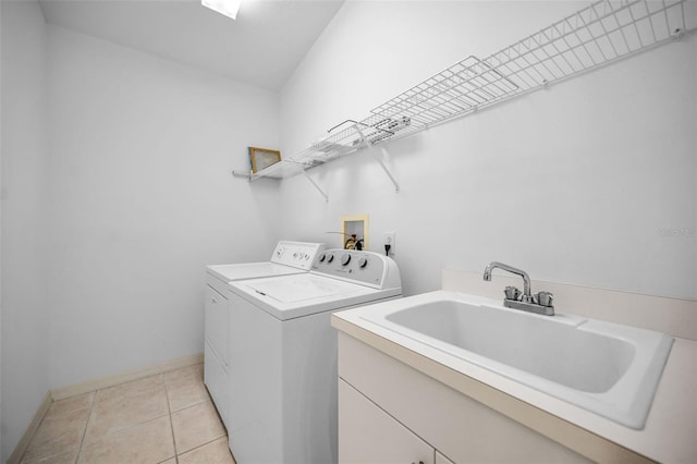 washroom with light tile patterned flooring, sink, and washing machine and clothes dryer