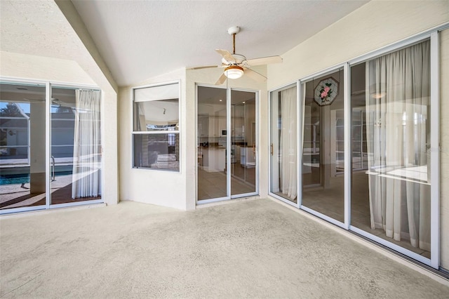 unfurnished sunroom with ceiling fan and vaulted ceiling