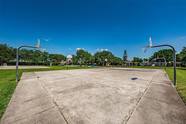 view of basketball court featuring a lawn and a playground