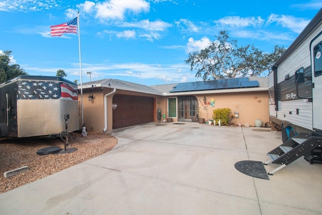 view of front facade with solar panels and a garage