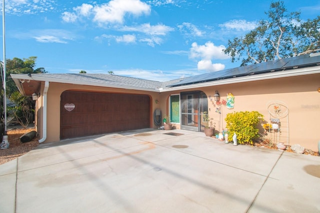 ranch-style home featuring solar panels and a garage