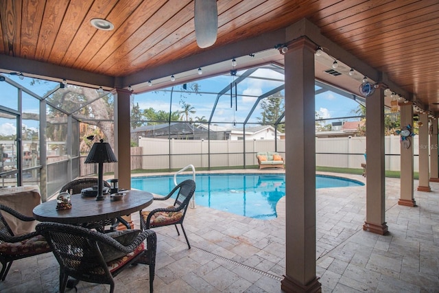 view of pool with glass enclosure and a patio area