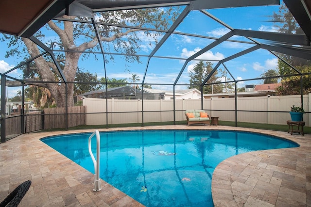 view of pool with glass enclosure and a patio area