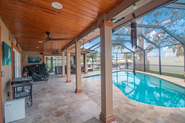 view of swimming pool with ceiling fan, a lanai, and a patio